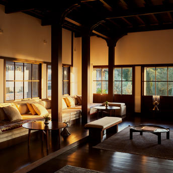 Ottoman-inspired lounge at Amanruya with warm lighting, traditional wooden beams, and yellow seating.