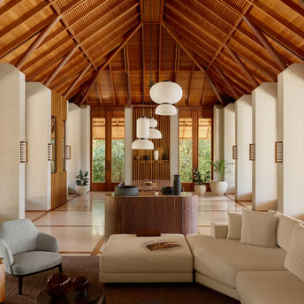 アマンヤラのフォーベッドルーム・トランクイリティ・ヴィラの広々としたリビングエリア、木製の高い天井と大きな窓から自然光が差し込む