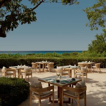 アマンヤラ リゾートのメインレストランからターコイズブルーの海を望む屋外ダイニングエリア。