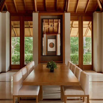 アマンヤラのヴィラダイニングルーム。木製の天井と大きな窓から緑が見える、落ち着いた食事空間。