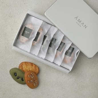 Aman Kyoto toiletries collection displayed in white packaging with fresh ginger root beside it.