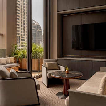 Heritage Room meeting space at Aman Nai Lert Bangkok, featuring seating area with city views and television.