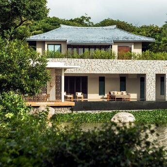 Lake Wellness Pool Villa exterior at Amanoi, Vietnam, with reflecting pond and lush vegetation.