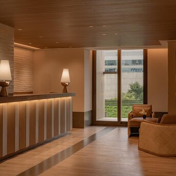 Aman Nai Lert Bangkok wellness clinic reception area with warm wood finishes and soft lighting.