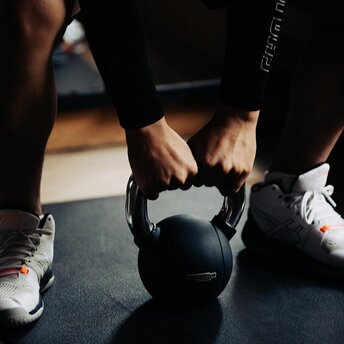 Hands gripping a kettlebell during a fitness session at Amanoi, Vietnam.