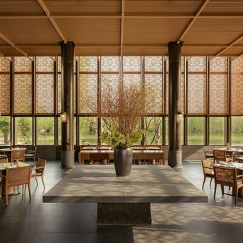 Dining pavilion at Amanyangyun with floor-to-ceiling windows overlooking gardens and natural landscape.