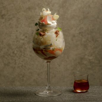 安缦东京酒店休闲酒吧的柑橘水果冰淇淋甜品，玻璃杯盛装，旁边放着一小杯红色饮料。