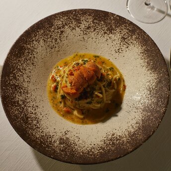 Signature dish plated in a shallow speckled bowl at Aman Tokyo hotel.