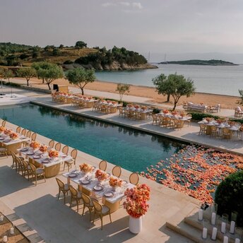 Celebration setup at Amanzoe resort with poolside seating and Aegean views.