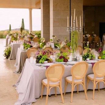 Elegantly dressed wedding banquet table at Amanzoe resort, adorned with floral arrangements and candlelight.