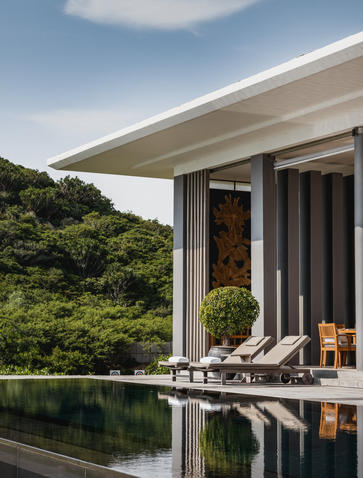 Amanoi beach club with open-air terrace overlooking tropical vegetation and infinity pool.