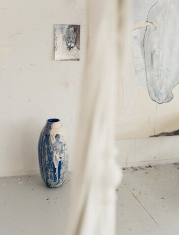 Studio portrait of Marina Karella at Amanzoe art exhibit in Greece, featuring ceramic vessels.